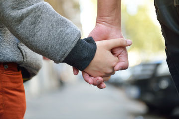 une personne qui tiens par la main un enfant